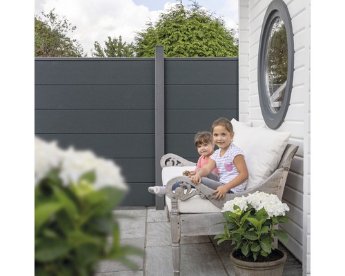 Sichtschutzzaun mit Kindern auf einer Bank im Garten