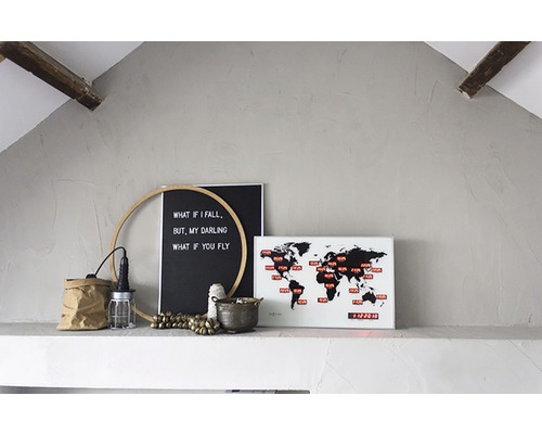 Dekoration mit Weltkarte, Zitat-Tafel und Lampe auf einem Regal