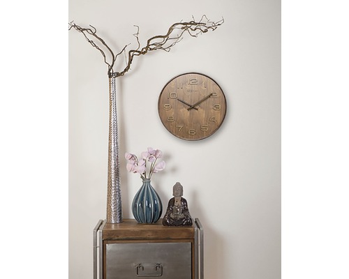 Wohnzimmerdekoration mit einer Uhr, Vasen und einer Buddhafigur auf einem Beistelltisch