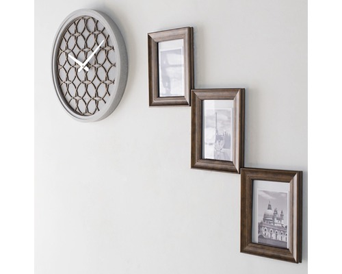 Wanduhr und drei Bilderrahmen an der Wand