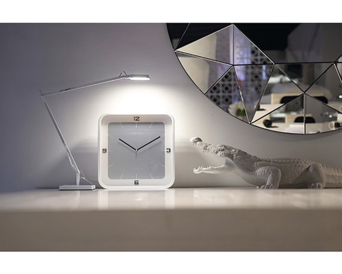 Dekoration mit Schreibtischlampe, Uhr und Krokodilfigur vor einem Spiegel