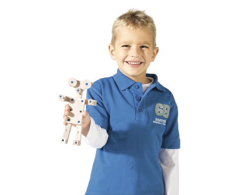 Ein Junge hält ein hölzernes Konstruktionsspielzeug in der Hand.
