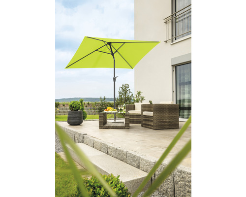 Quadratischer Sonnenschirm auf einer Terrasse mit Gartenmöbeln vor einem Haus.