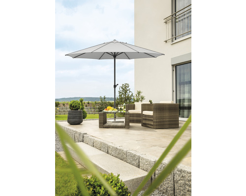 Terrasse mit Sonnenschirm, Rattansitzgruppe und Pflanzgefäß