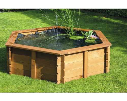 Hexagonaler Gartenteich aus Holz mit Wasserpflanzen und Springbrunnen auf Rasen