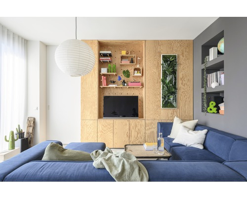 Wohnzimmer mit blauem Ecksofa, Holzvertäfelung und Dekorationen