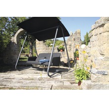 Gartenschaukel mit Überdachung vor einer Steinmauer