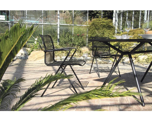 Gartenszene mit Tisch und Stühlen aus Metall auf einer Terrasse