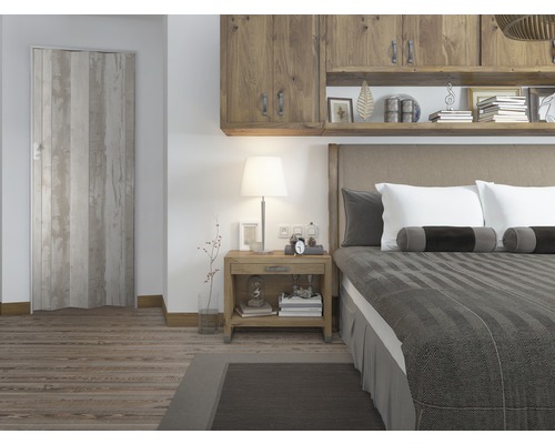 Schlafzimmer mit Holzbett, Nachttisch, Schrank und Falttür