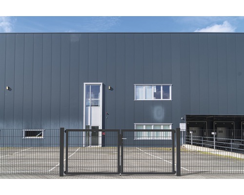 Außenansicht eines Lagergebäudes mit Metallfassade und Zaun