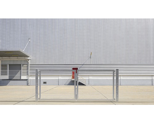 Industriegebäude mit Metallfassade und Zaun