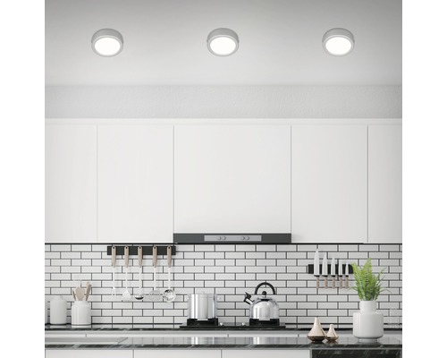 Moderne Küche mit weißen Schränken und drei runden Deckenleuchten