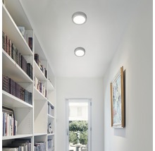 Zwei runde Deckenleuchten in einem hellen Flur mit Bücherregal