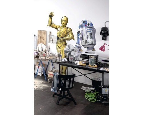 Szene mit C-3PO und R2-D2 Figuren an einem Tisch mit verschiedenen Gegenständen.