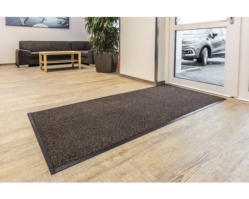 Fußmatte im Eingangsbereich eines Raumes mit heller Holzoptik.