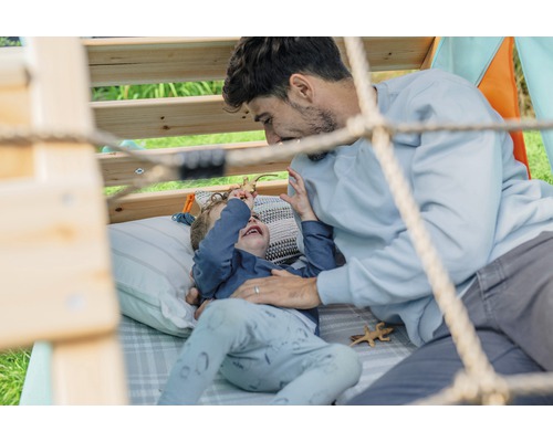 Vater und Kind spielen im Gartenhaus mit Spielzeug