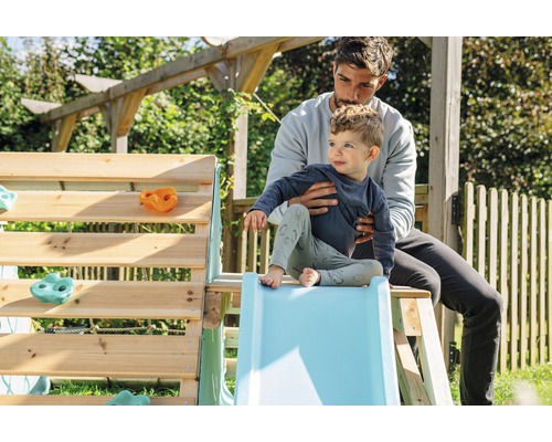 Vater und Kind am Klettergerüst mit Rutsche im Garten.