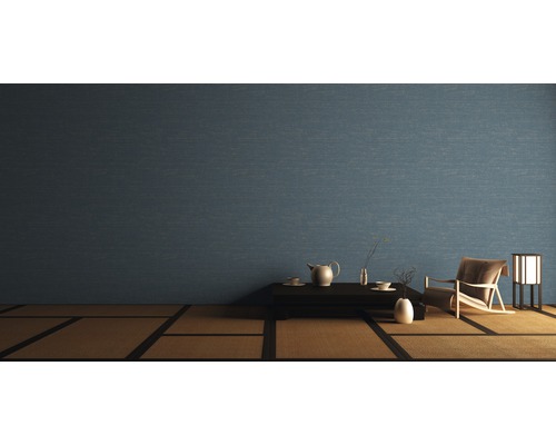 Wohnraum mit blauer Wandtapete, Tisch, Teeservice, Sessel und Lampe