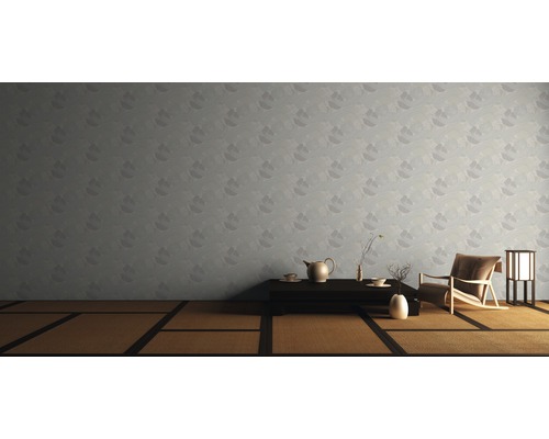 Ein Wohnzimmer mit einer gemusterten Tapete, einem Tatamiboden, einem niedrigen Tisch und einem Sessel.