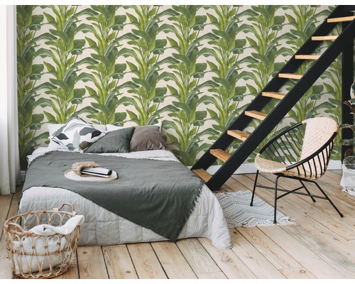 Schlafzimmer mit einer Wandtapete mit Pflanzenmotiven, Bett, Treppe und einem Stuhl.