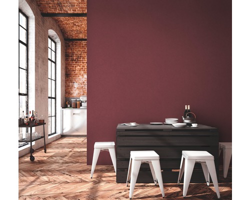 Heller Raum mit Holzboden, Backsteinwand, Barwagen, Esstisch aus Paletten und weißen Hockern vor einer Wand