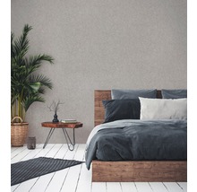 Schlafzimmer mit Holzbett, Nachttisch, Zimmerpflanze und Teppich