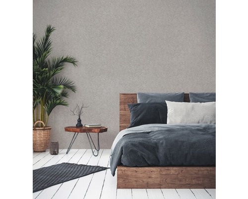 Schlafzimmer mit Holzbett, Nachttisch, Zimmerpflanze und Teppich