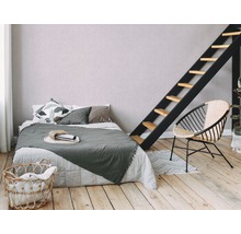Schlafzimmer mit Bett, Leiter, Sessel und Wäschekorb auf Holzboden