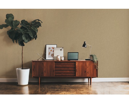 Wohnraum mit brauner Tapete, Kommode, Zimmerpflanze und Schreibtischlampe