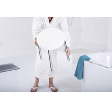 Frau im Bademantel hält einen Duschhocker