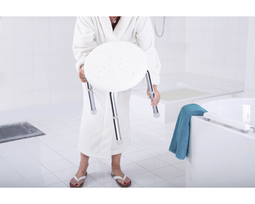 Frau im Bademantel hält einen Duschhocker
