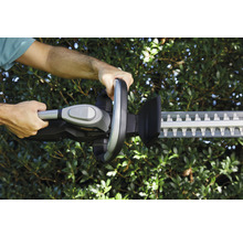 Person bedient eine Heckenschere zum Schneiden von Hecken.