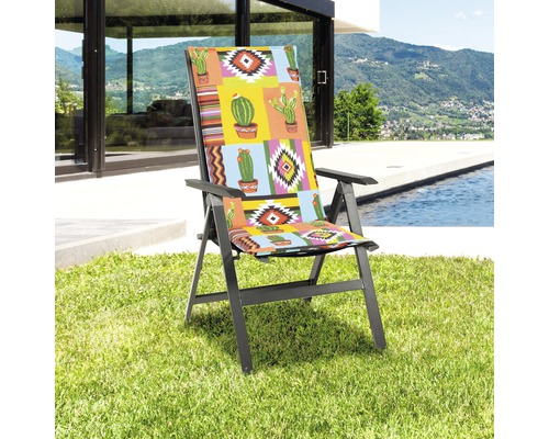 Gartensessel mit Auflage im Kakteenmuster auf Rasen vor Pool und Haus