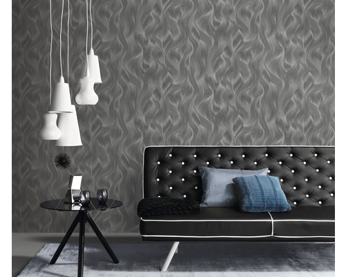 Wohnzimmer mit grauer Tapete, schwarzem Sofa und weißen Lampen
