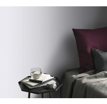 Schlafzimmer mit Bett, Nachttisch und Tapete