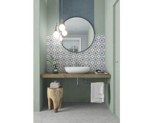 Badezimmer mit Waschbecken, Spiegel, gemusterten Fliesen und Holzhocker