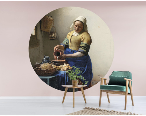 Wandbild mit dem Gemälde ''Das Milchmädchen'' von Jan Vermeer, kombiniert mit einem Stuhl und Tisch im Raum.