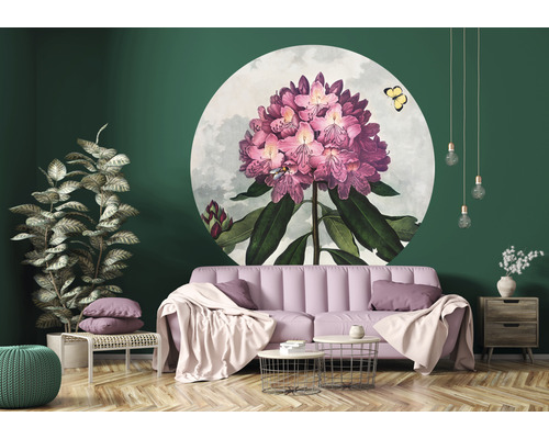 Wohnzimmer mit rosa Sofa, Couchtisch, Pflanze und runder Wanddekoration mit Blumenmotiv