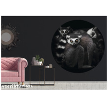 Wohnzimmer mit pinkem Sofa, Beistelltischen und einer Wand mit einem großen, runden Wandtattoo, das Lemuren zeigt