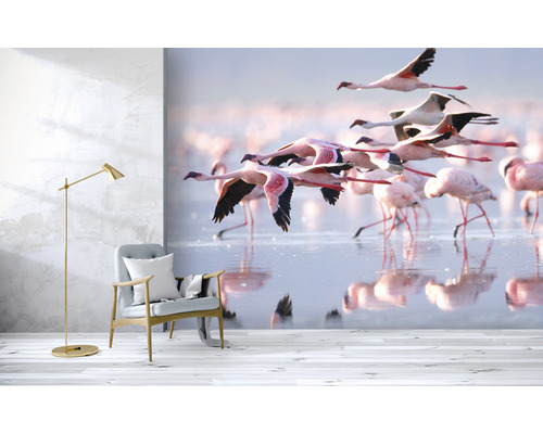 Szene mit einem Sessel, einer Stehlampe und einer Fototapete mit Flamingos im Flug über dem Wasser
