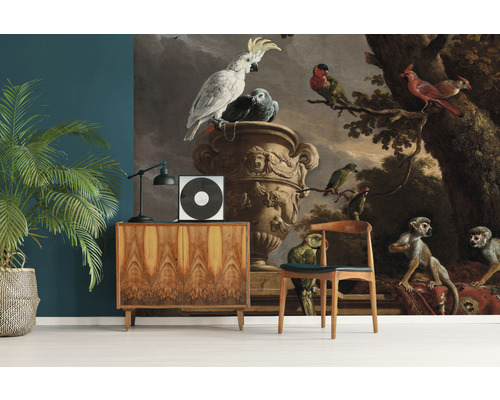 Dekoratives Wandbild mit Vogel- und Affenmotiv hinter Anrichte und Stuhl