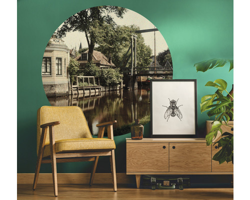 Dekoratives Wohnzimmer mit gelbem Sessel, Kommode, Zimmerpflanze und Wandtattoo mit Stadtansicht