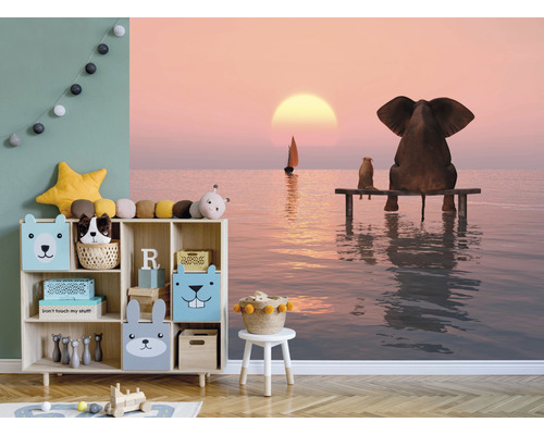 Kinderzimmer mit Regal, Spielzeug und Wandbild mit Elefant- und Hundemotiv am Meer bei Sonnenuntergang