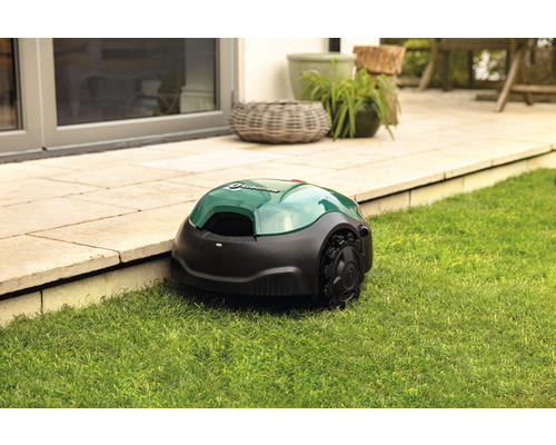 Rasenmähroboter auf Rasen neben einer Terrasse