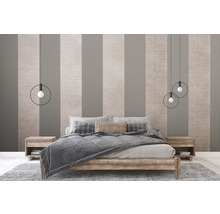 Schlafzimmer mit Bett, Nachttischen und Pendelleuchten vor gestreifter Tapete