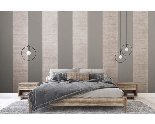 Schlafzimmer mit Bett, Nachttischen und Pendelleuchten vor gestreifter Tapete