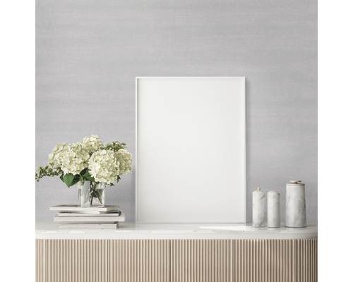 Dekorative Szene mit Bilderrahmen, Blumen, Büchern und Marmorobjekten auf einem Schrank.