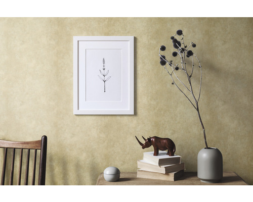 Dekoratives Interieur mit Bilderrahmen, Pflanzenmotiv und Holzdekoration auf einem Tisch