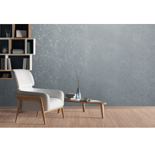 Wohnzimmer mit hellblauer Marmortapete, Sessel und Bücherregal
