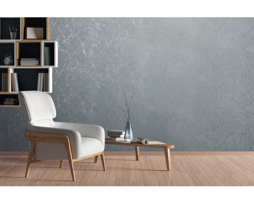 Wohnzimmer mit hellblauer Marmortapete, Sessel und Bücherregal
